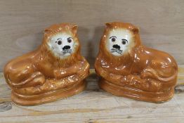 A PAIR OF VINTAGE STAFFORDSHIRE LIONS