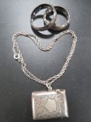 AN ANTIQUE SILVER VESTA CASE ON SILVER CHAIN TOGETHER WITH TWO NAPKIN RINGS