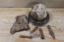 AN ANTIQUARIAN CANNONBALL ON STAND, BRONZE? AXE HEAD ETC