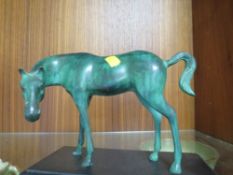 A CAST METAL MODEL OF A HORSE ON A PLINTH