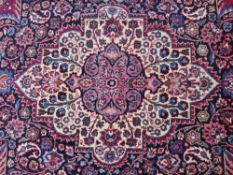 A LARGE EASTERN RED WOOLLEN RUG 508 x 310 cm