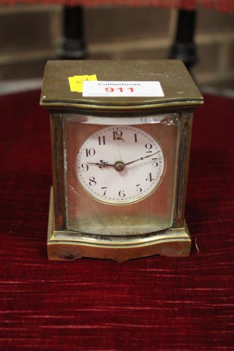 A SMALL BRASS TRAVEL CLOCK IN A BOW FRONTED CASE, A/F, H 9 cm