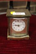 A SMALL BRASS TRAVEL CLOCK IN A BOW FRONTED CASE, A/F, H 9 cm