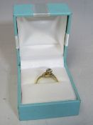 A LADIES 18CT GOLD DIAMOND RING, central raised diamond with smaller diamonds set to shank