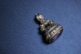 A GILT METAL FOB SEAL WITH CARVED INTAGLIO AMETHYST OF A WINGED MAN USING A POSHER ENTITLED '