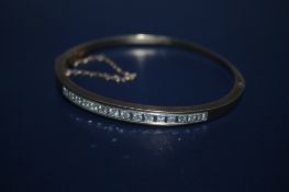 A HALLMARKED 9 CARAT GOLD DIAMOND BANGLE, set with fifteen brilliant cut diamonds in a squared