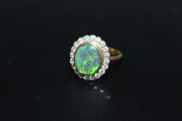 A HALLMARKED 18 CARAT GOLD OPAL AND DIAMOND RING, the central oval opal being of an estimated 2.33