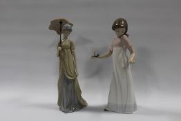 A NAO FIGURE OF A GIRL HOLDING A CANDLE TOGETHER WITH ANOTHER FIGURINE