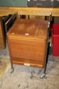A RETRO TEAK AND CHROME FILING CABINET ON CASTORS