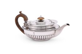 A GEORGE III SILVER CIRCULAR TEA POT