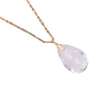A ROCK CRYSTAL PENDANT ON A GOLD COLOURED CHAIN
