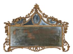 A CARVED GILTWOOD AND COMPOSITION OVERMANTEL WALL MIRROR IN GEORGE III STYLE