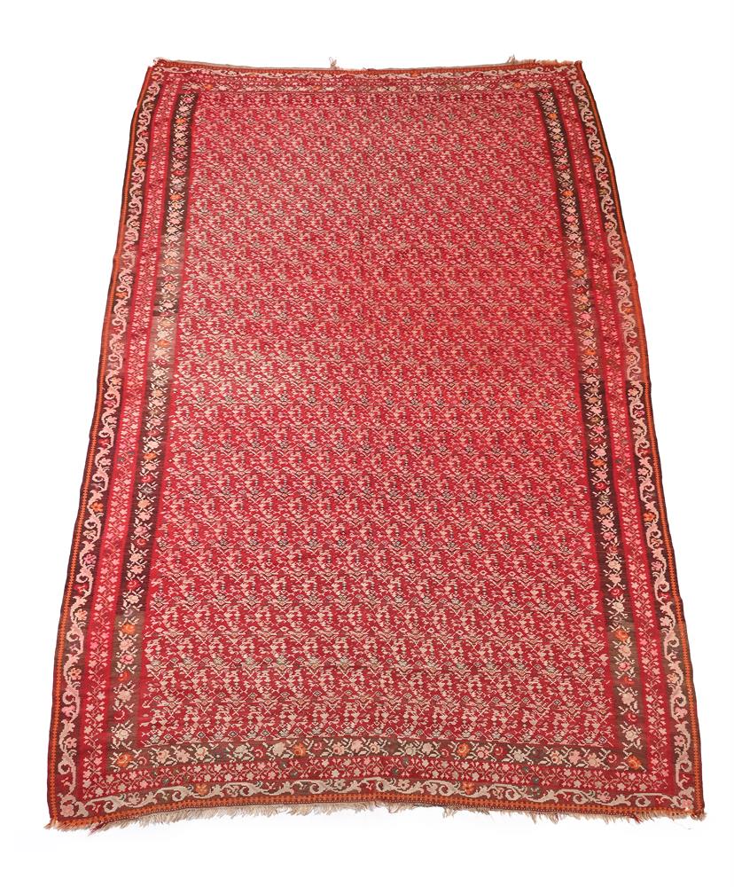 A SENNEH RED GROUND KELIM CARPET