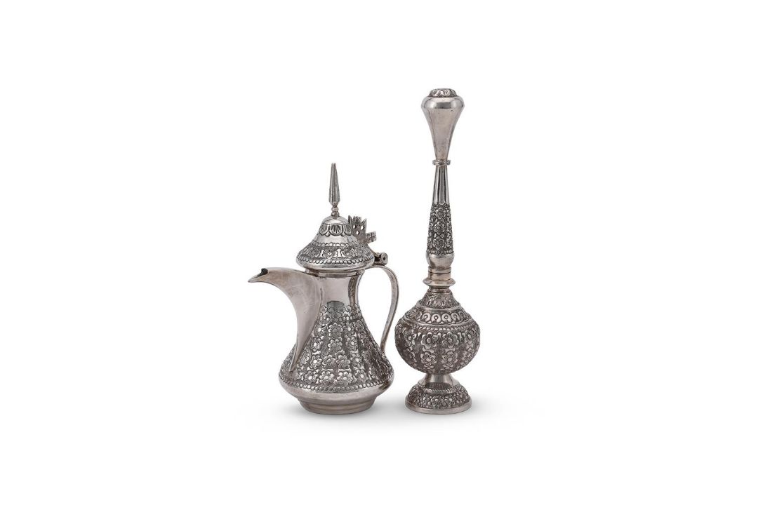 AN ARABIC SILVER COLOURED COFFEE POT AND ROSE WATER SPRINKLER