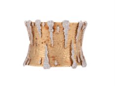 A DIAMOND AND GOLD COLOURED CUFF BANGLE