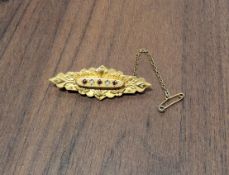 A Victorian 9ct mourning brooch, set with rubies & seed pearls, the reverse with a glazed section