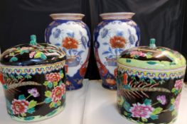 A pair of cylindrical jars and covers,  painted with fanciful birds and chrysanthemums in colours on