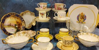 A Dresden cup and saucers, decorated with alternating panels of courting couples, gilt scroll