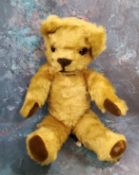 A mid 20th century jointed mohair bear, glass eyes, small ears, felt pads, 33cm high, c.1940