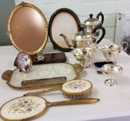 A four-piece E.P.N.S. tea service, paneled sides, c.1940;  a gilt metal mounted dressing table set;