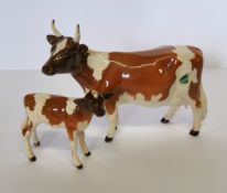A Beswick Ayshire cow, CH. Newton Tinkle, printed mark;  a similar calf (2)