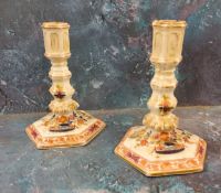 A pair of 19th century Meissen candlesticks, decorated in blue red and green, hexagonal sconces