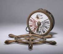 A BRASS-CASED SHIPS ENGINE ORDER TELEGRAPH AND AN ENGINE ROOM VALVE WHEEL
