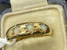 Jewellery: Yellow metal ring set with three round cabouchon cut opals, estimated weight of (3) 0.