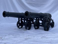 MARITIME: A pair of cast iron cannon on carriages with tapering barrels and armorial crest to the