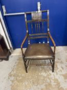 19th cent. Ebonised armchair, the back with a painted panel of dancing figures, turned spindles