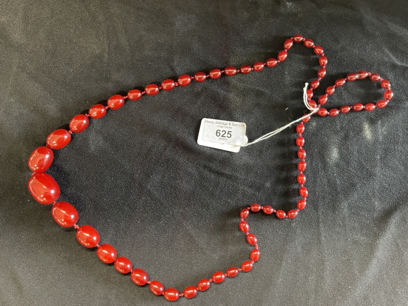 Jewellery: Necklet of sixty-nine graduated oval amber beads, ranging from 30mm x 21mm to 10mm x 4mm. - Image 2 of 3