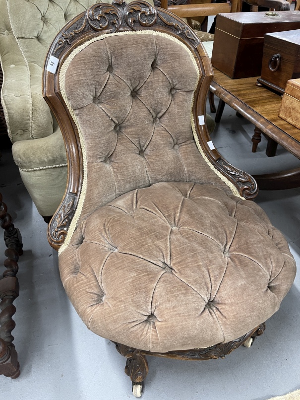20th cent. Two nursing armchairs, one carved walnut on ceramic castors upholstered in brown, the
