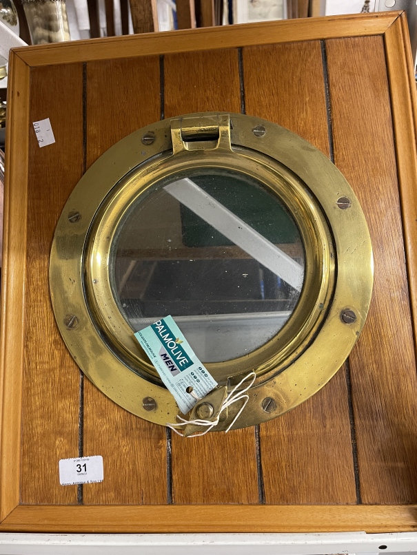 20th cent. Brass porthole mounted in an oak surround. 18ins.