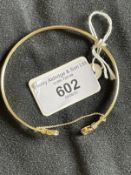 Jewellery: Yellow metal torque style bangle each end set with a single oval cut peridot, estimated