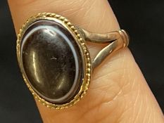 Jewellery: Yellow metal 1979 ring set with an oval cabouchon cut banded agate, tests as 9ct gold.