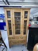 20th cent. Stripped pine display unit, two opening doors over two drawers. Approx. 67ins. x 35ins. x