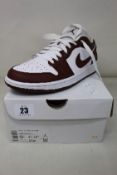 A pair of women's as new Nike Air Jordan 1 Low in White/Bronze Eclipse-White (Size UK 7).