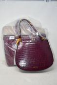 A Carvela Jamie winged wine croc print tote bag and a Carvela horseshoe shape wine tote bag.