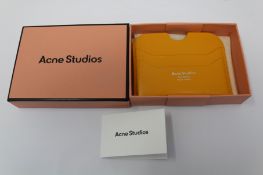 A boxed as new Acne Studios Leather Card Holder in Pumpkin Orange.
