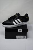 A pair of as new Adidas Tyshawn Low CBLACK/FTWWHT/GOLDMT (Size UK 10.5) (Box has some damage).