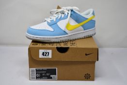 A pair of Nike Dunk Low GS Blue Chill/Yellow Strike-White (Size UK 6).