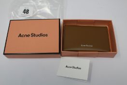 A boxed as new Acne Studios Folded Leather Card Holder in Camel Brown.