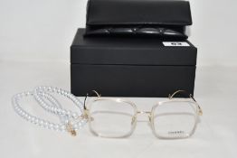 A pair of pre-owned Chanel 2195 Square Lens Eyeglasses with a Glass Pearl Glasses Chain, comes