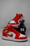 A pair of Nike Air Jordan 1 mid SE (GS) Chile Red/White Pollen (UK 5.5) (Damage to outer box).