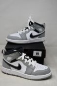 A pair of boxed as new Nike Air Jordan 1 mid light smoke grey PS (UK13C).