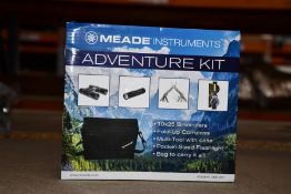A boxed as new Meade adventure kit binoculars to include compass, multi tool, flashlight and 10 x 25