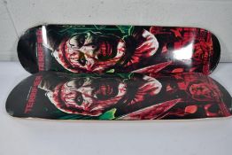 Two as new skateboard decks with a Damen Leone film Terrifier motif to deck