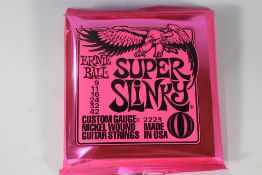 Twelve sets of Ernie Ball 2223 Super Slinky Custom Gauge Nickel Wound Electric Guitar Strings.