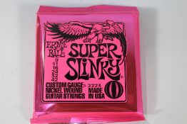 Twelve sets of Ernie Ball 2223 Super Slinky Custom Gauge Nickel Wound Electric Guitar Strings.