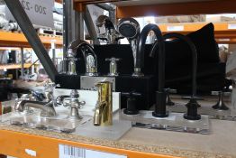 Seven various taps and a set of cast iron bath feet.